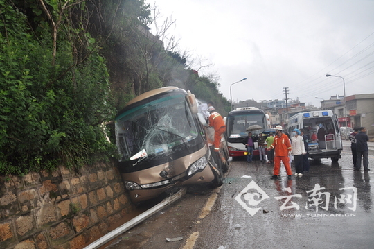  大巴车侧翻路边水沟伤14人 云南个旧消防紧急救援（图）