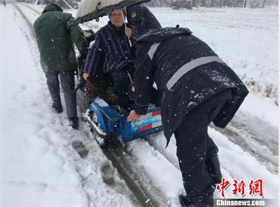 南京六合区的城管队员用小推车送老人过马路。马惠琴 摄