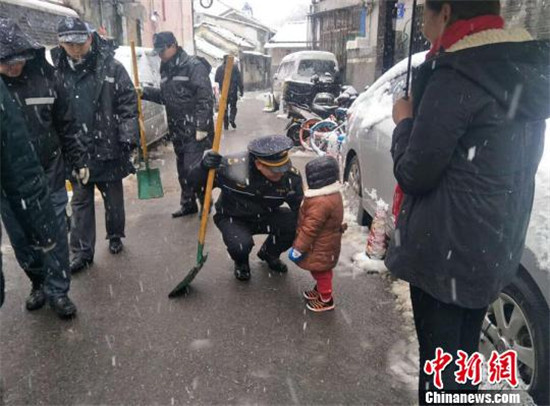 南京牵牛巷居民特地带小女儿出来感谢为大家扫雪的城管队员和环卫工人。云波 摄