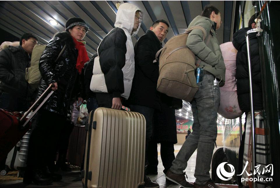 ２月１日凌晨，背着大包小包检票的乘客。