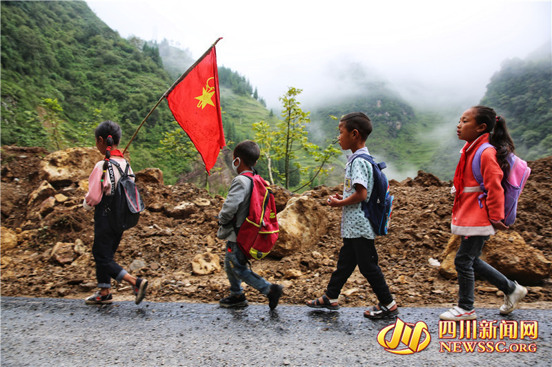 举着鲜红的队旗 大凉山孩子结伴去上学