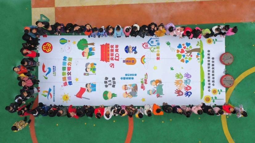 松江小昆山镇举办“学雷锋”主题活动，小朋友们以巨幅填色画“献礼”