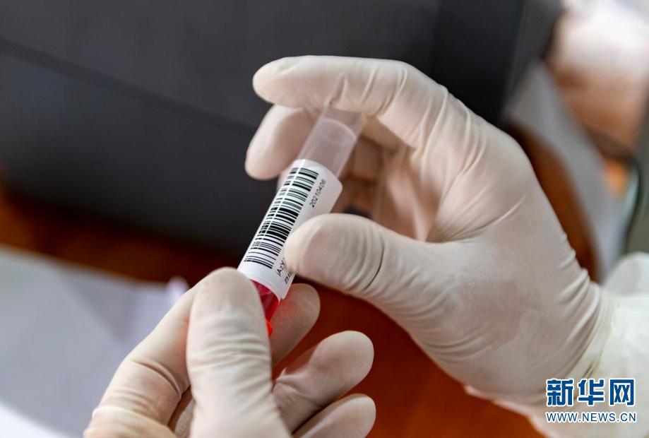 4月6日,在瑞丽市目瑙社区一核酸检测点,医务人员为核酸采样管贴上标签