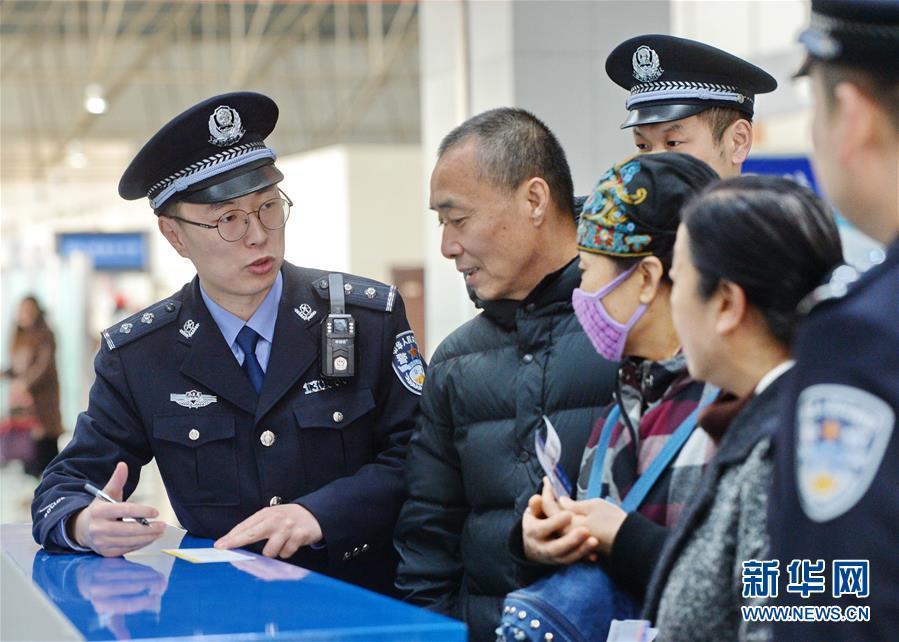 1月1日,石家庄出入境边防检查站民警王悦峰(左)为旅客讲解出境有关
